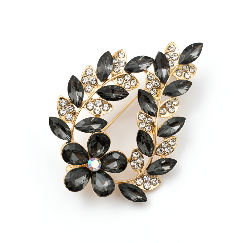 Decorative brooch with black gemstones and gold accents on a white background