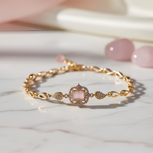 Gold bracelet with a pink gemstone on a marble surface