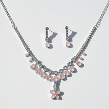 Jewelry set with pink and blue stones on a light gray background