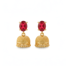 Gold earrings with red gemstones on a white background