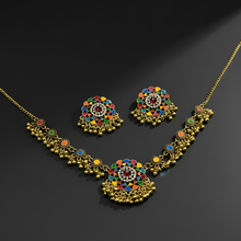 Gold necklace and earrings with colorful stones on a dark background
