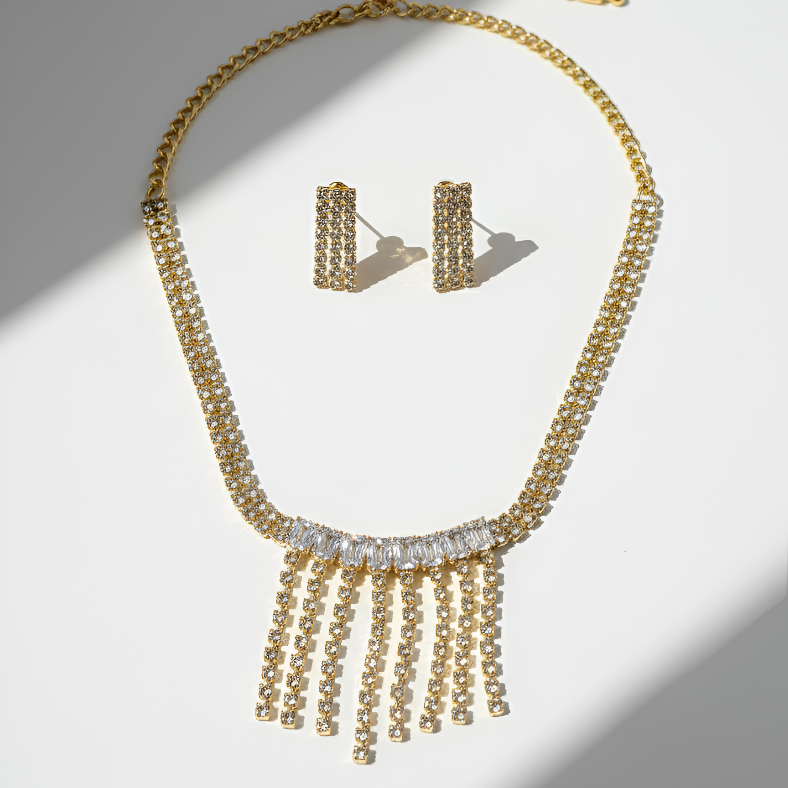 Gold necklace and earrings on a light gray background
