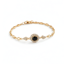 Gold bracelet with a black gemstone on a white background