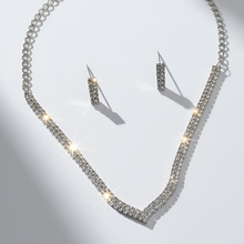 Silver necklace and earrings set on a light gray background