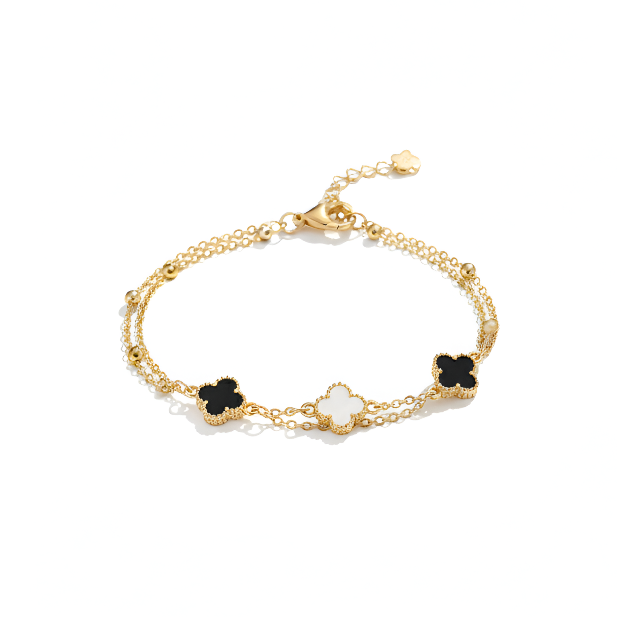 Gold bracelet with black flower charms on a white background