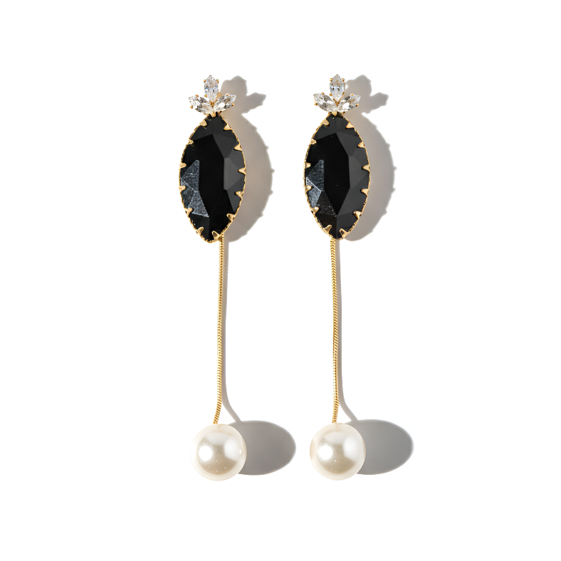 Pair of earrings with black gemstones and pearl drops on a white background