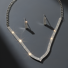 Silver necklace and earrings on a dark gray background
