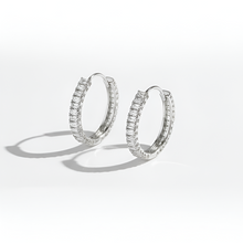 Pair of silver hoop earrings on a white background