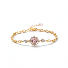 Gold bracelet with a pink gemstone on a white background