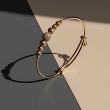 Gold bracelet with beads on a two-tone background