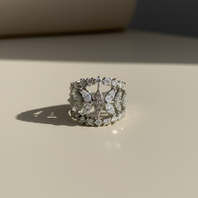 Silver ring with butterfly design on a beige surface