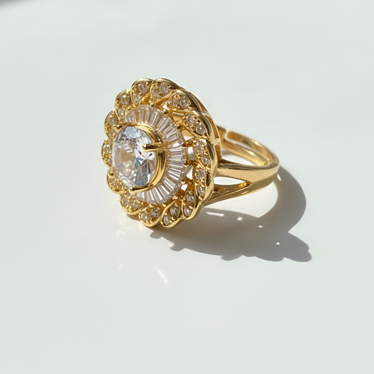 Gold ring with a large central gemstone on a white surface
