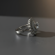 Silver ring with intricate design on a dark surface