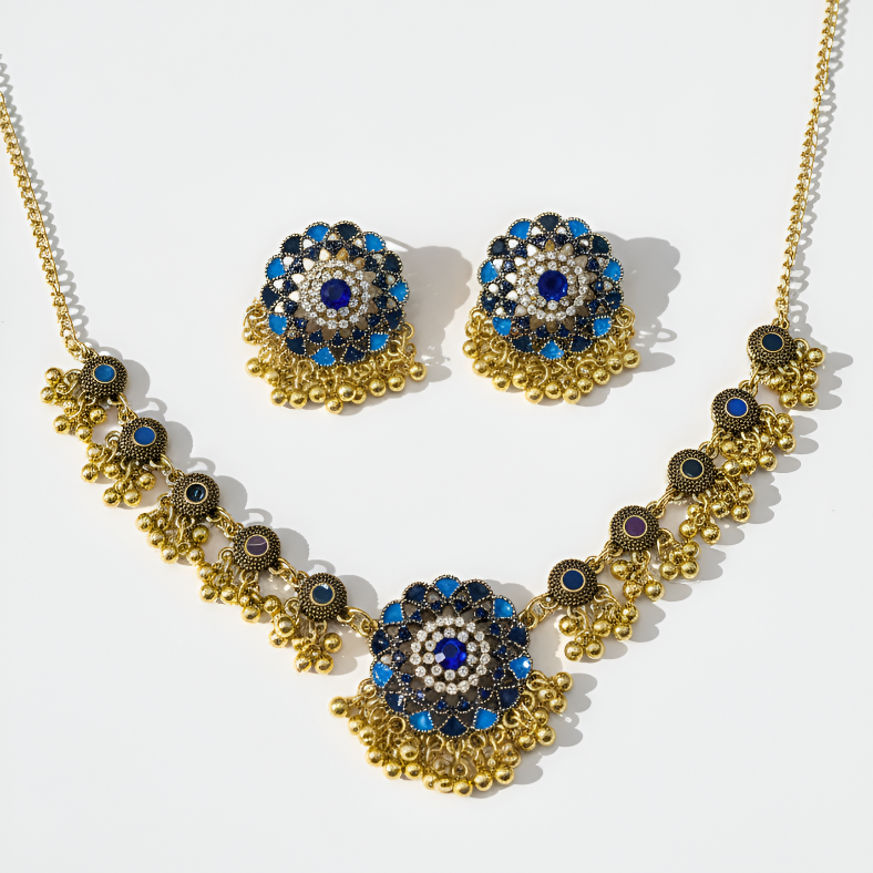 Gold necklace and earrings with blue and black stones on a white background