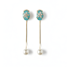 Pair of earrings with turquoise gemstones and pearl drops on a white background