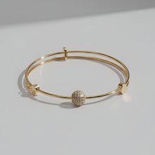 Gold bracelet with a decorative element on a light gray background