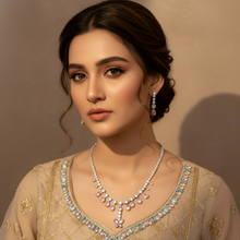 Woman wearing a beige embroidered outfit with jewelry against a neutral background