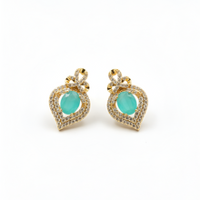 Pair of earrings with turquoise stones and gold accents on a white background