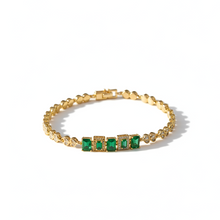 Gold bracelet with green gemstones on a white background