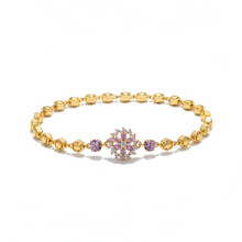 Gold bracelet with a snowflake charm on a white background
