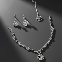 Diamond necklace, earrings, and bracelet set on a dark background